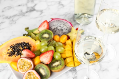 Delicious exotic fruits and wine on white table