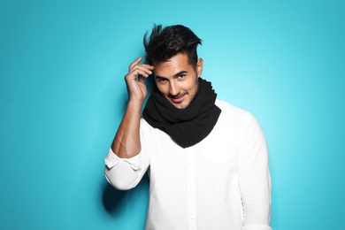 Young man with trendy hairstyle posing on color background