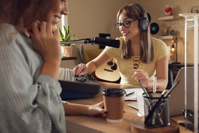 Photo of Radio host interviewing young woman in modern studio