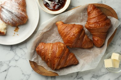 Photo of Tasty croissants on white marble table, flat lay