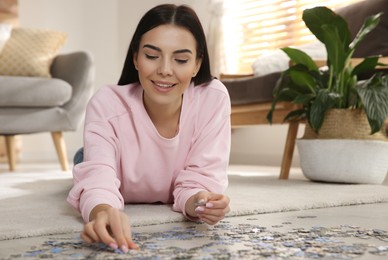 Young woman playing with puzzles on floor at home