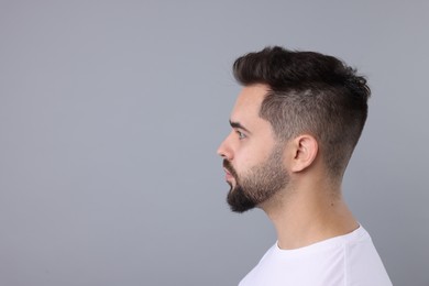 Man with healthy hair on light grey background, space for text