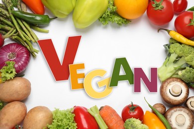 Image of Word Vegan and fresh vegetables on white background, flat lay