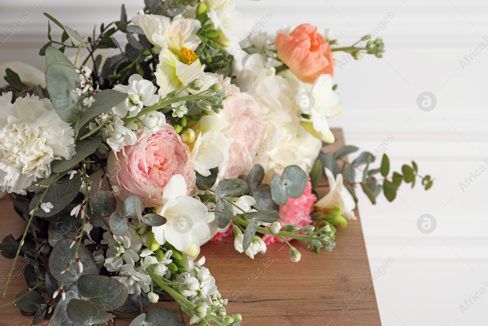 Photo of Bouquet of beautiful flowers on wooden table, closeup