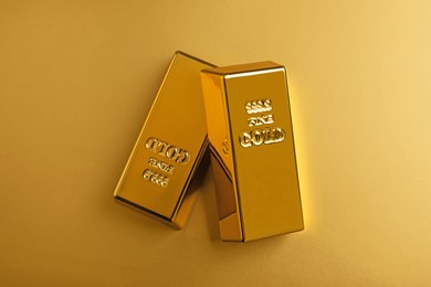Photo of Shiny gold bars on color background, flat lay
