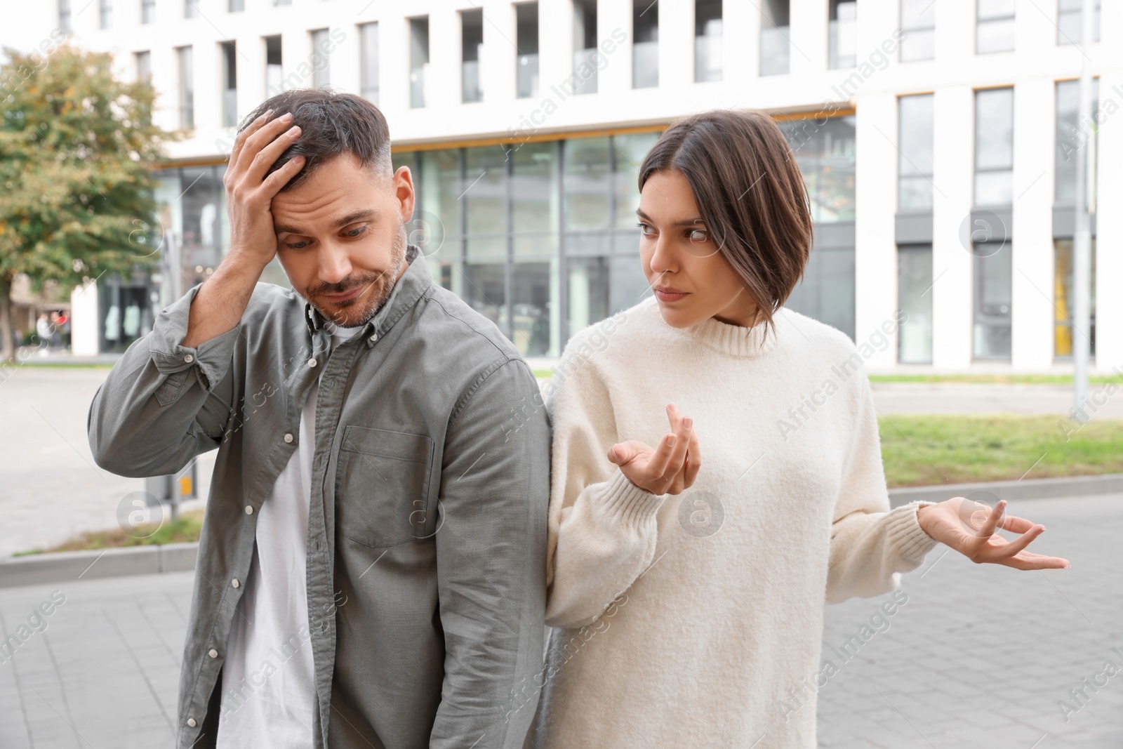 Photo of Couple arguing on city street. Relationship problems