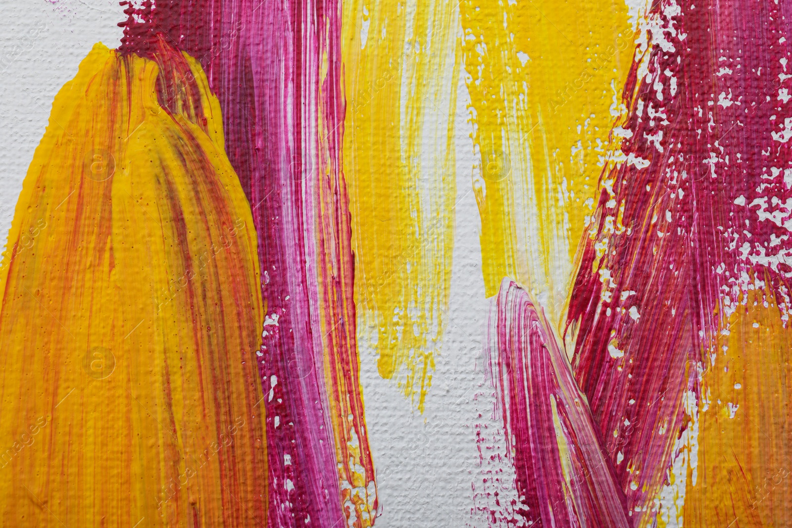 Photo of Strokes of colorful oil paints on white canvas, closeup