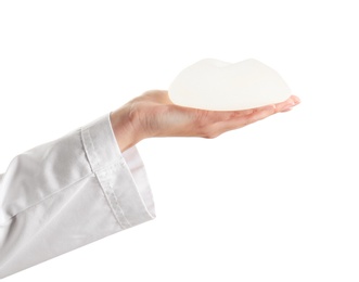 Photo of Doctor holding silicone implant for breast augmentation on white background. Cosmetic surgery