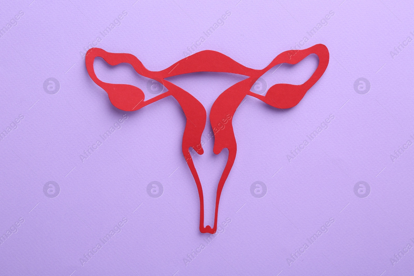 Photo of Reproductive medicine. Paper uterus on violet background, top view