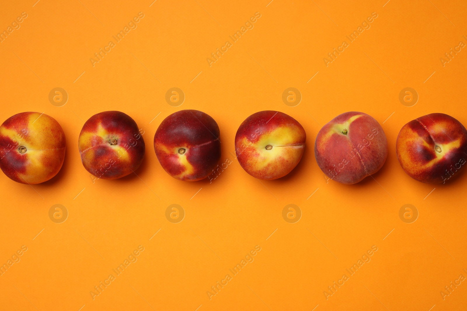 Photo of Flat lay composition with ripe peaches on orange background, space for text