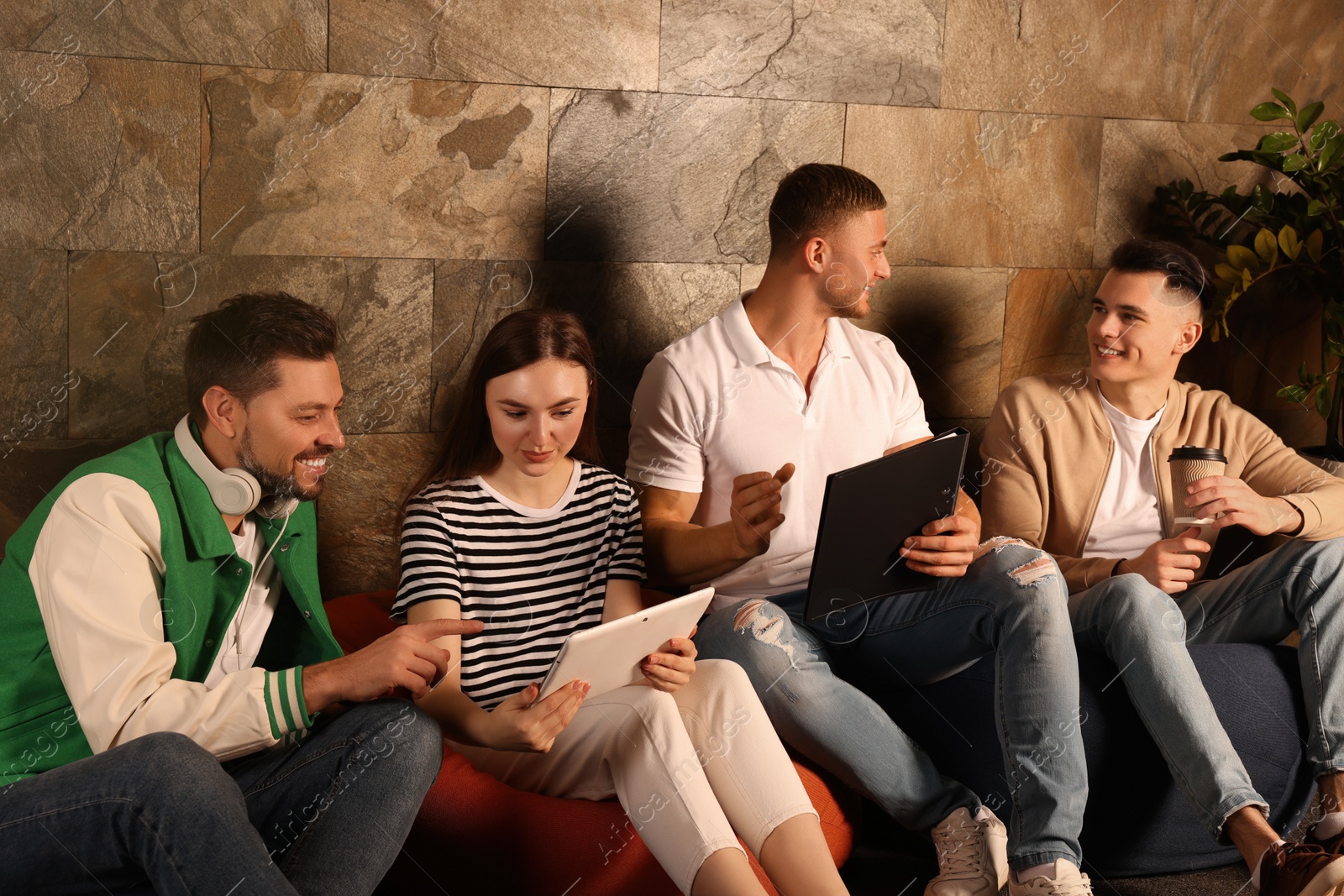 Photo of Office employees enjoying break together in recreation room at work