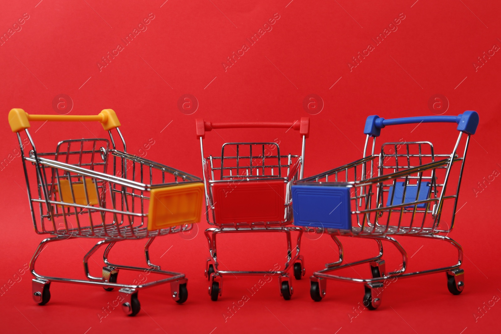 Photo of Different empty shopping trolleys on color background