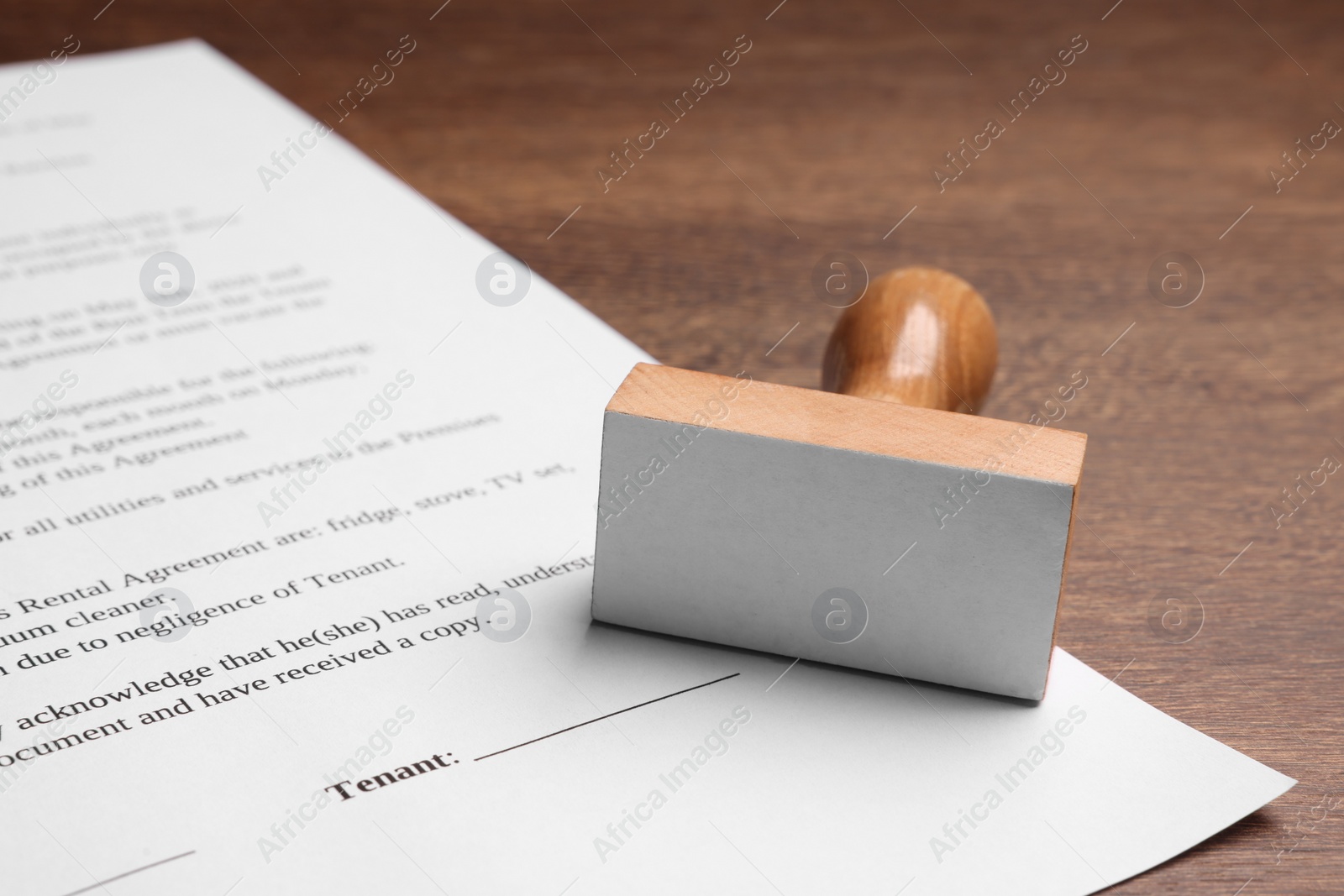 Photo of One stamp tool and document on wooden table, closeup