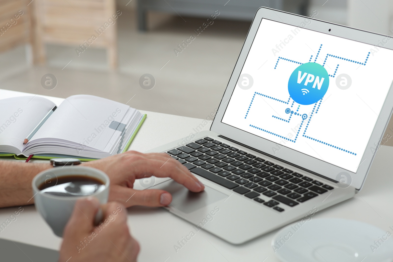 Image of Man using laptop with switched on VPN at desk indoors, closeup