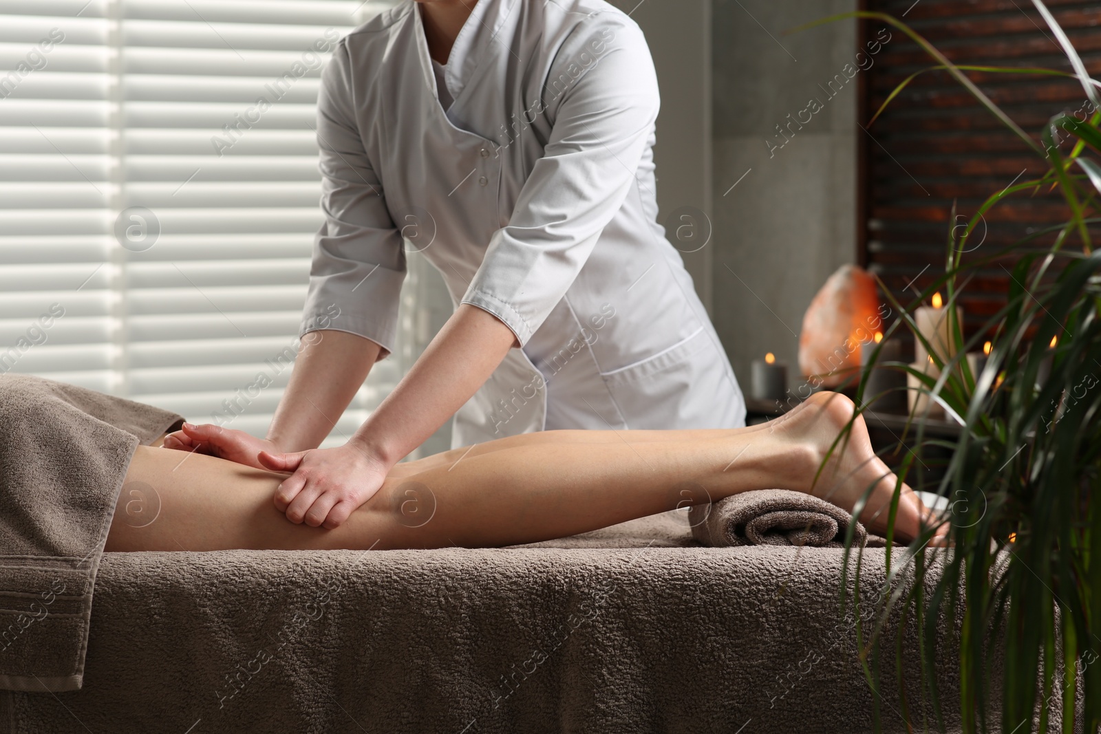 Photo of Woman receiving leg massage in spa salon, closeup