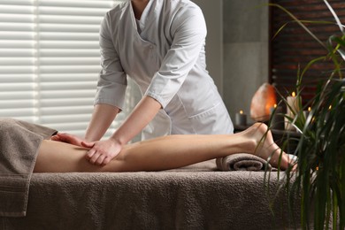 Woman receiving leg massage in spa salon, closeup