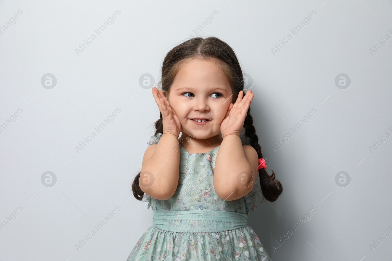 Photo of Cute little girl on light grey background