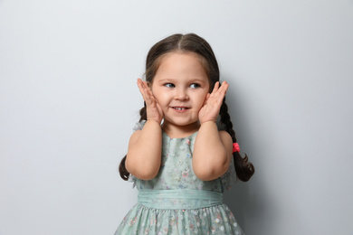 Photo of Cute little girl on light grey background