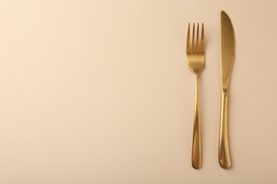 Photo of Stylish cutlery on beige table, top view. Space for text