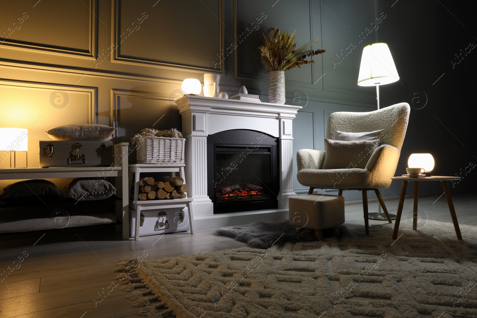 Photo of Beautiful fireplace, different decor and armchair in living room. Interior design