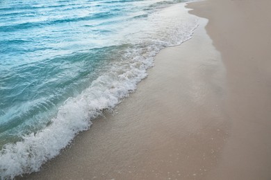 Sea waves rolling onto sandy tropical beach