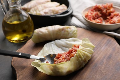 Photo of Preparing stuffed cabbage rolls on grey table, closeup