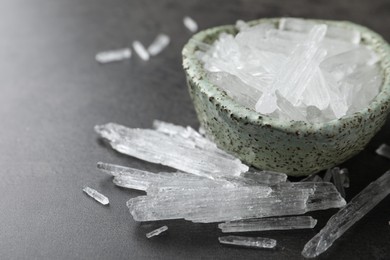 Photo of Menthol crystals in bowl on grey background, closeup