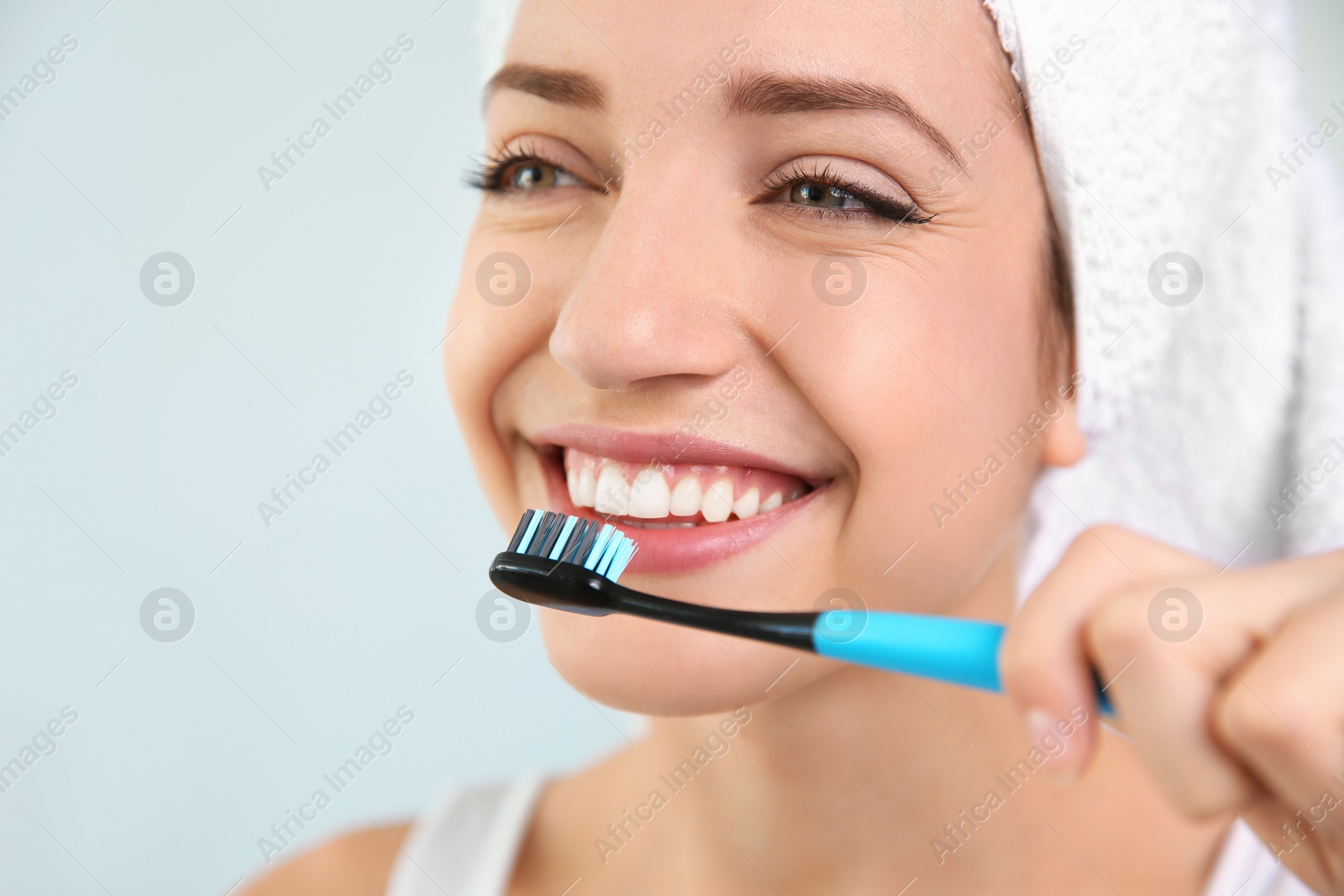 Photo of Young woman with toothbrush on blurred background, closeup