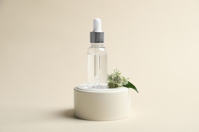 Photo of Bottle of cosmetic oil and flower on beige background