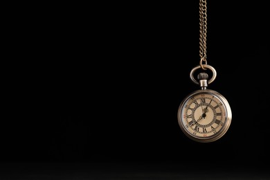 Stylish pendulum on black background, space for text. Hypnotherapy session