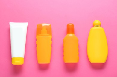 Suntan products on pink background, flat lay