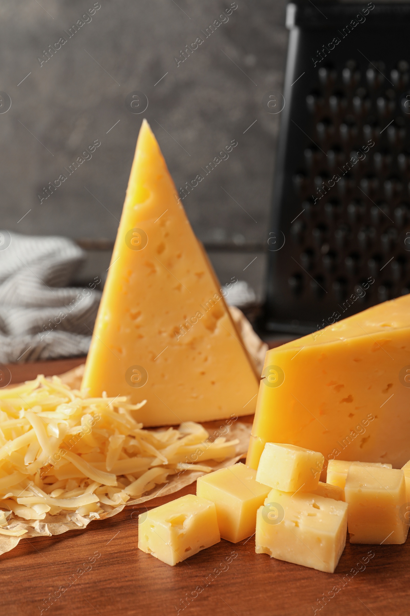 Photo of Grated and cut delicious cheese on board