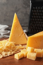 Photo of Grated and cut delicious cheese on board