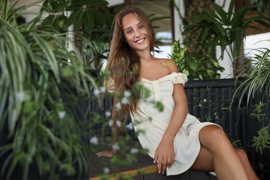 Photo of Beautiful young woman sitting on indoor terrace