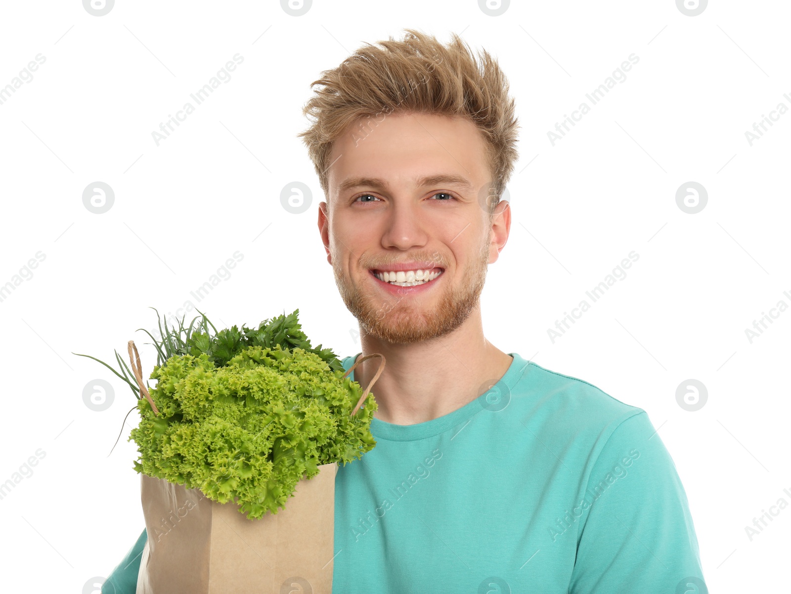 Photo of Young man with bag of fresh vegetables on white background