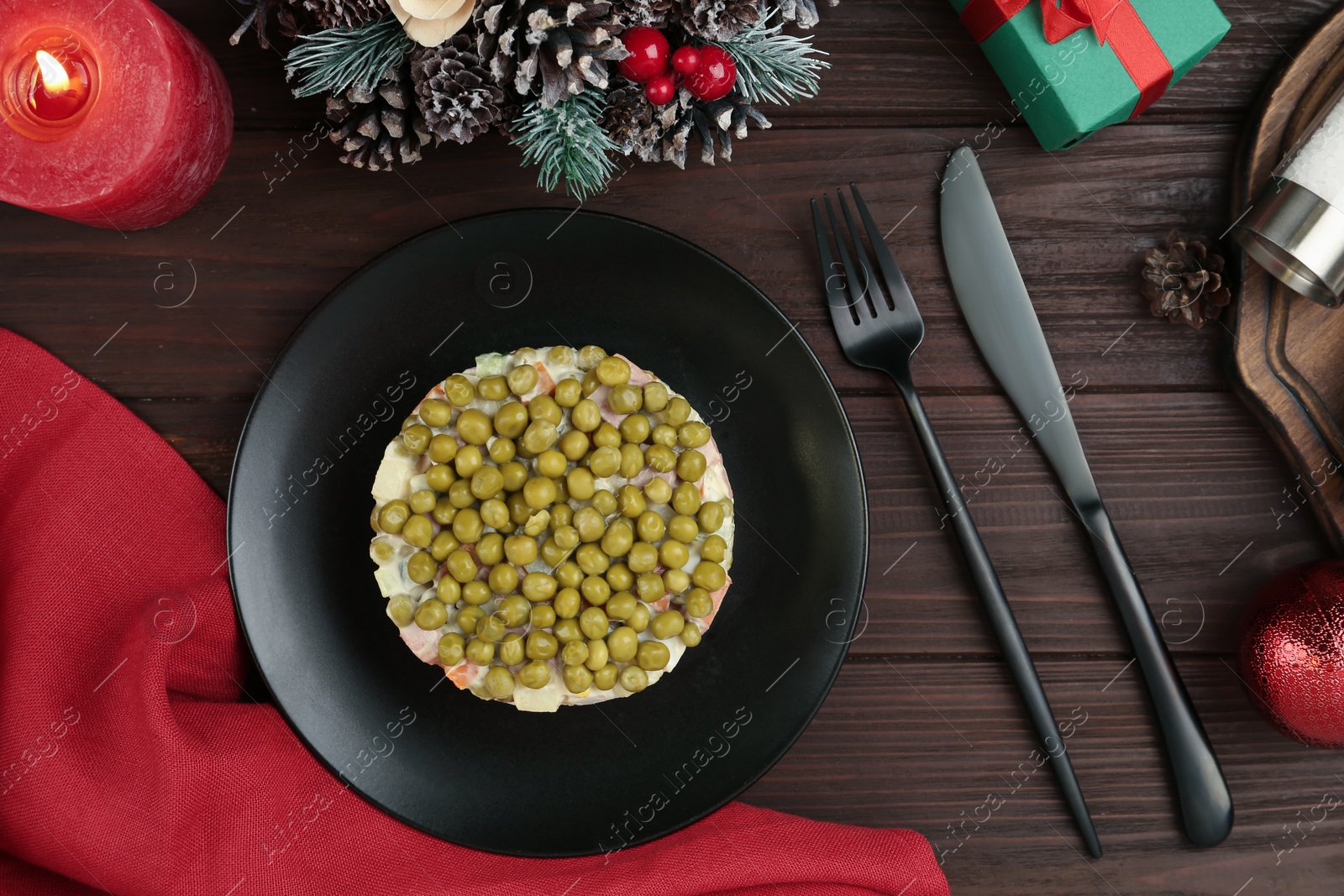 Photo of Traditional russian salad Olivier served on wooden table, flat lay