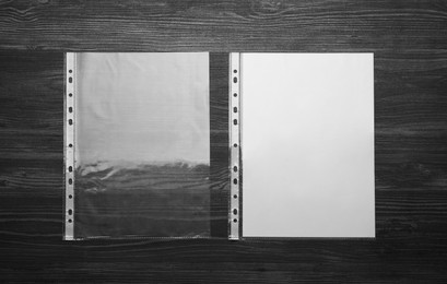 Photo of Punched pockets on black wooden table, flat lay