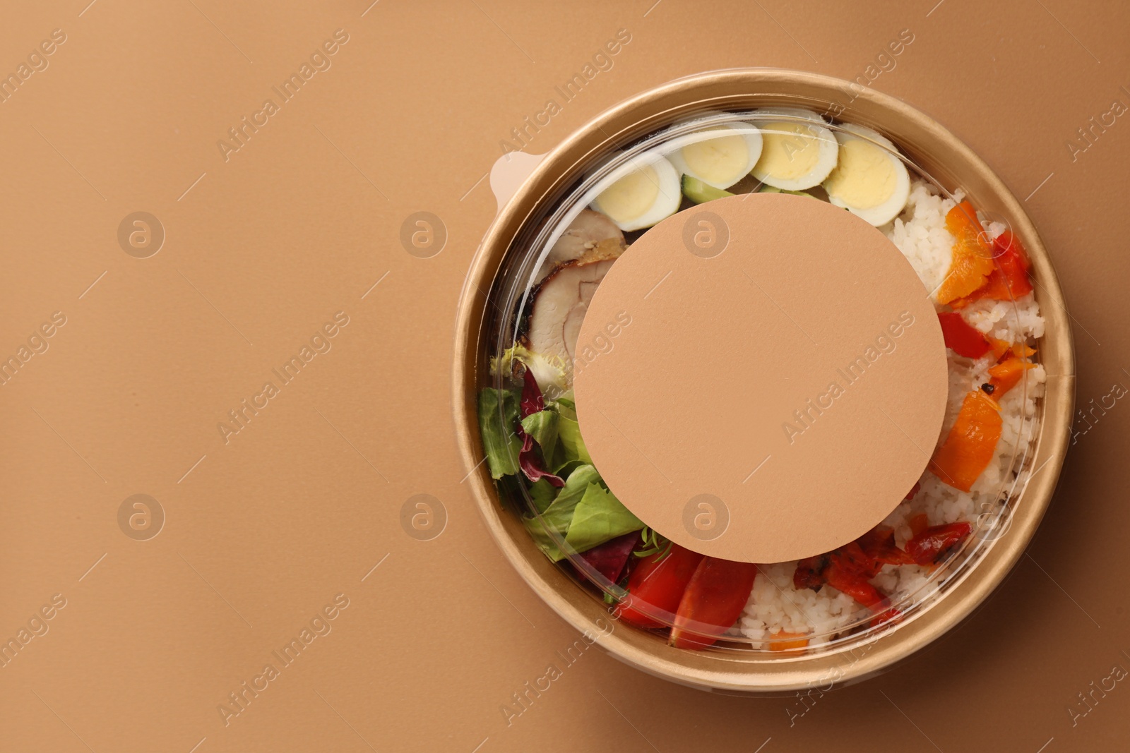 Photo of Tasty food in container on beige background, top view. Space for text