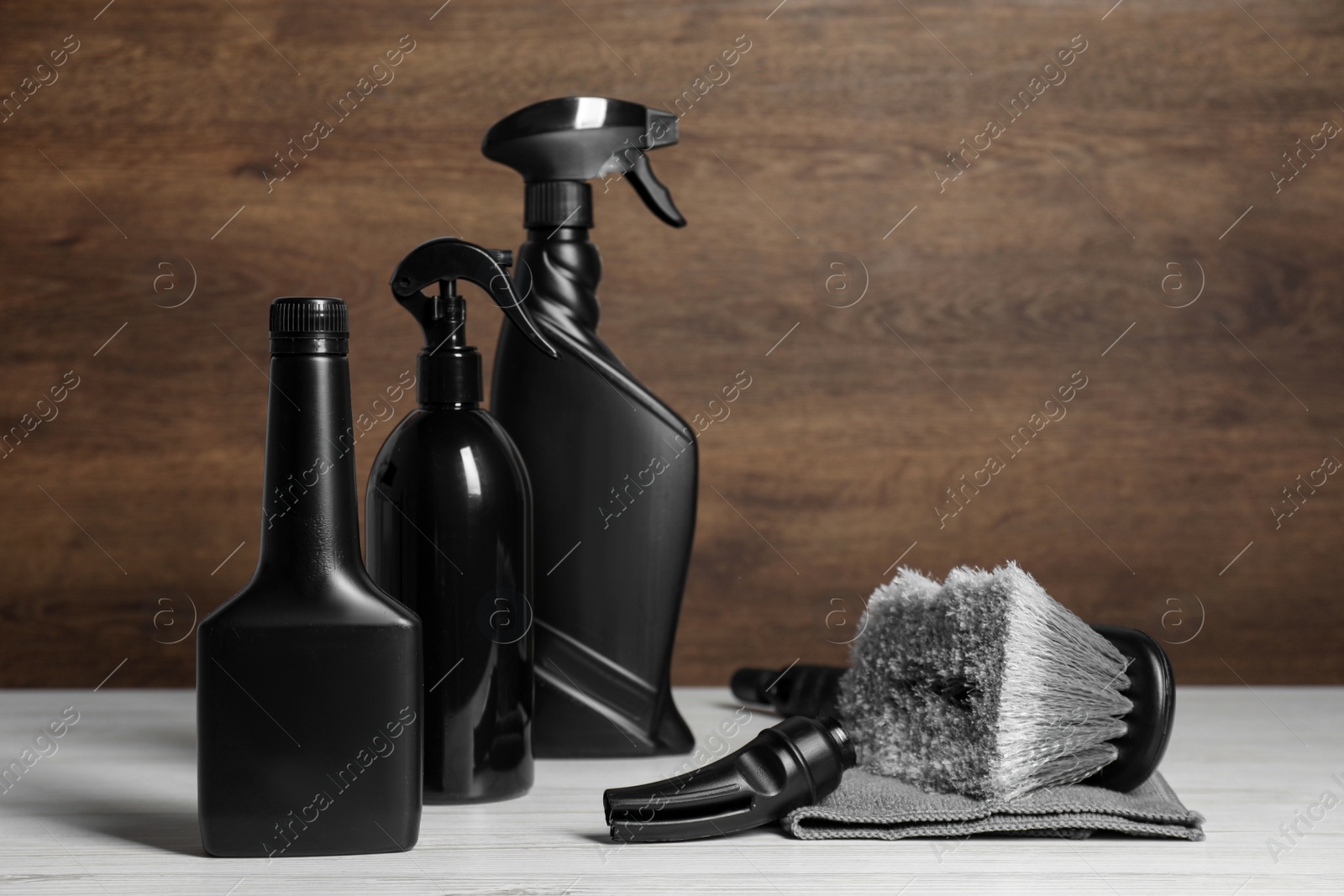 Photo of Car cleaning products, brush and microfiber fabric on white wooden table