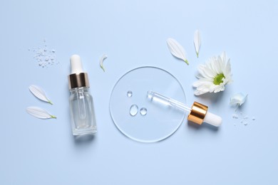 Photo of Bottle of cosmetic serum, pipette and flowers on light blue background, flat lay