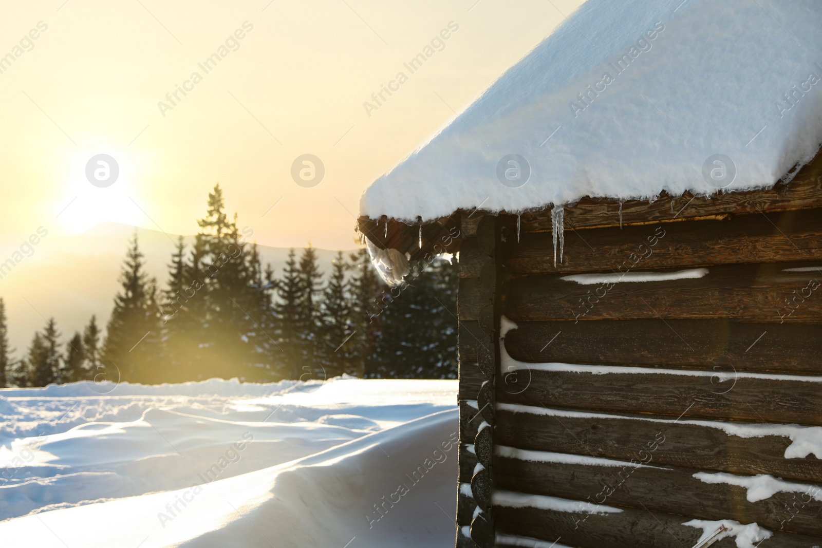 Photo of Wooden house with icicles on snowy day. Winter vacation