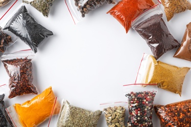 Photo of Plastic bags with different spices on white background, top view