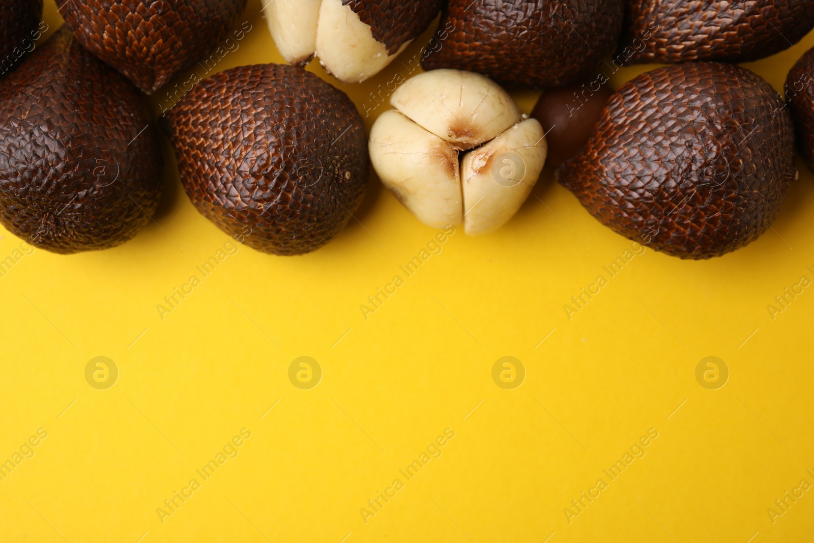 Photo of Fresh salak fruits on yellow background, flat lay. Space for text