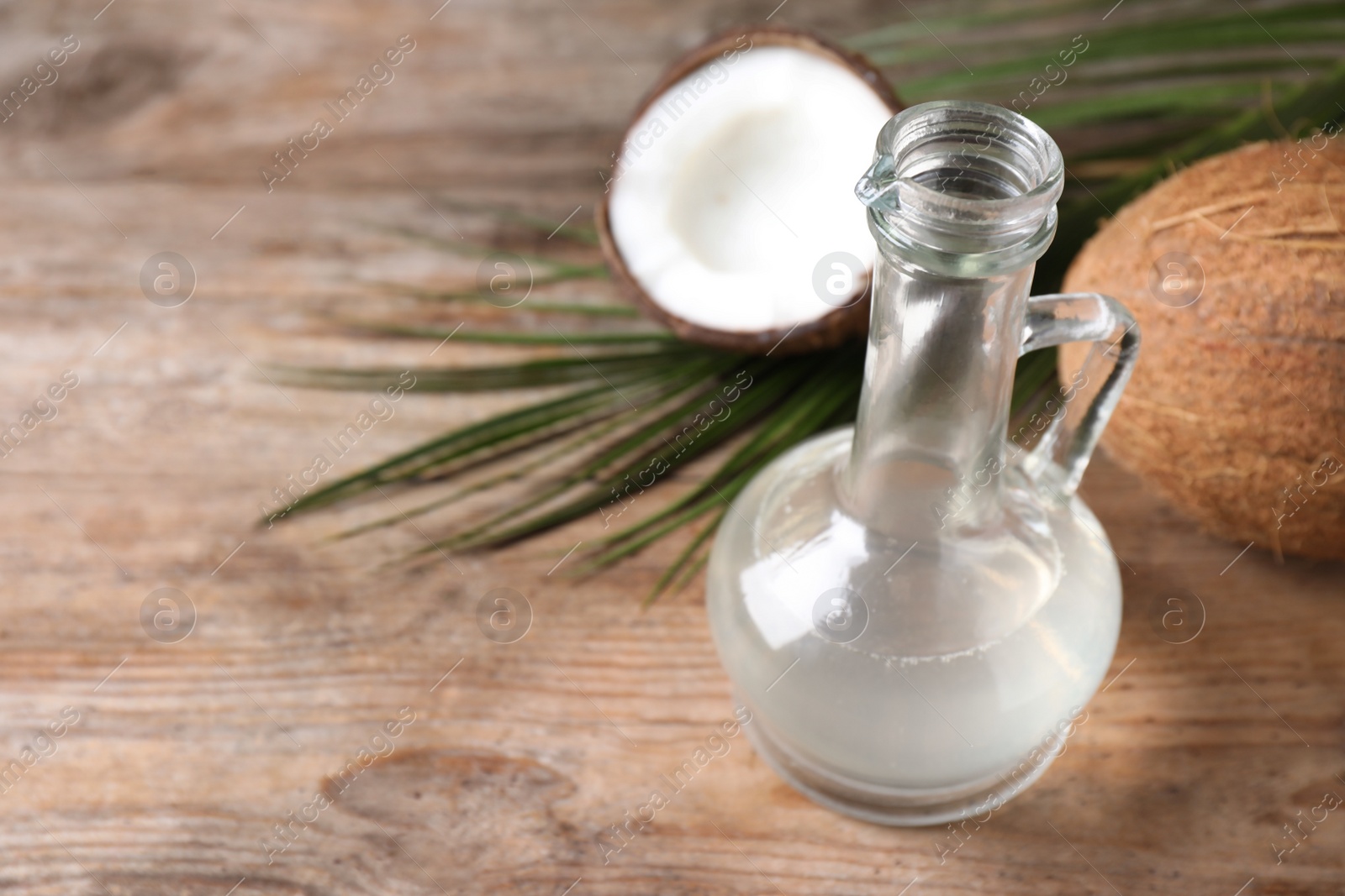 Photo of Coconut oil on wooden table. Space for text