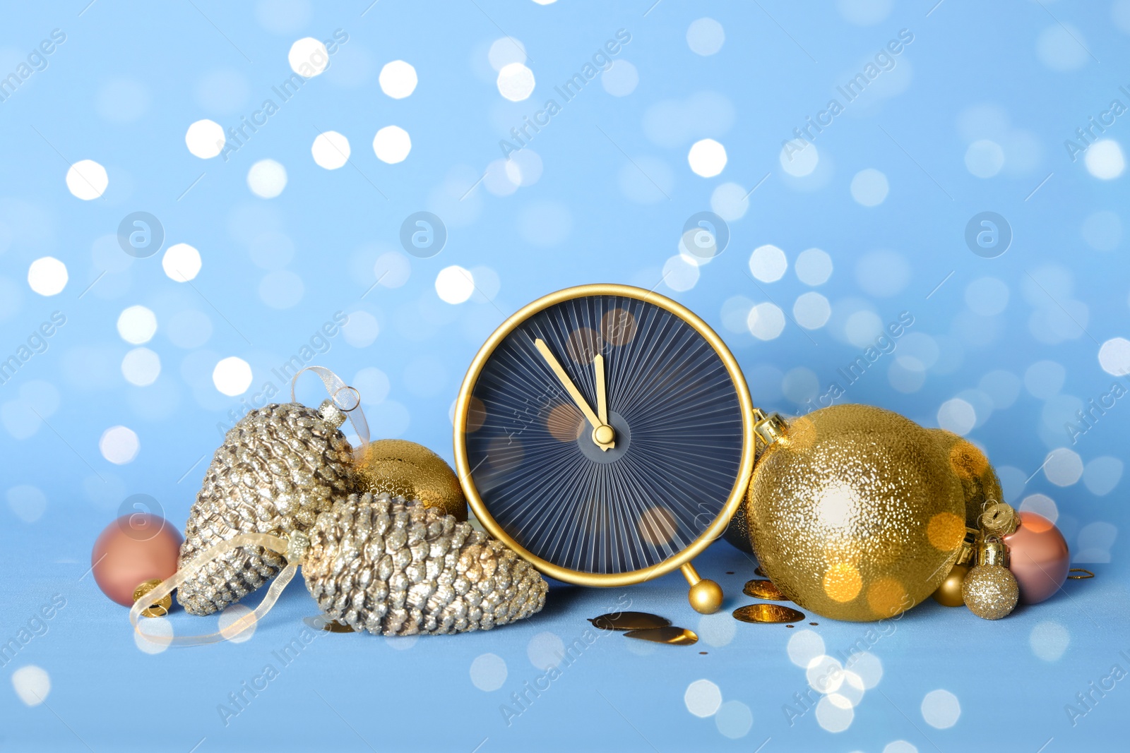 Photo of Stylish clock with Christmas decor on light blue background. New Year countdown