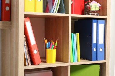 Colorful binder office folders and other stationery on shelving unit