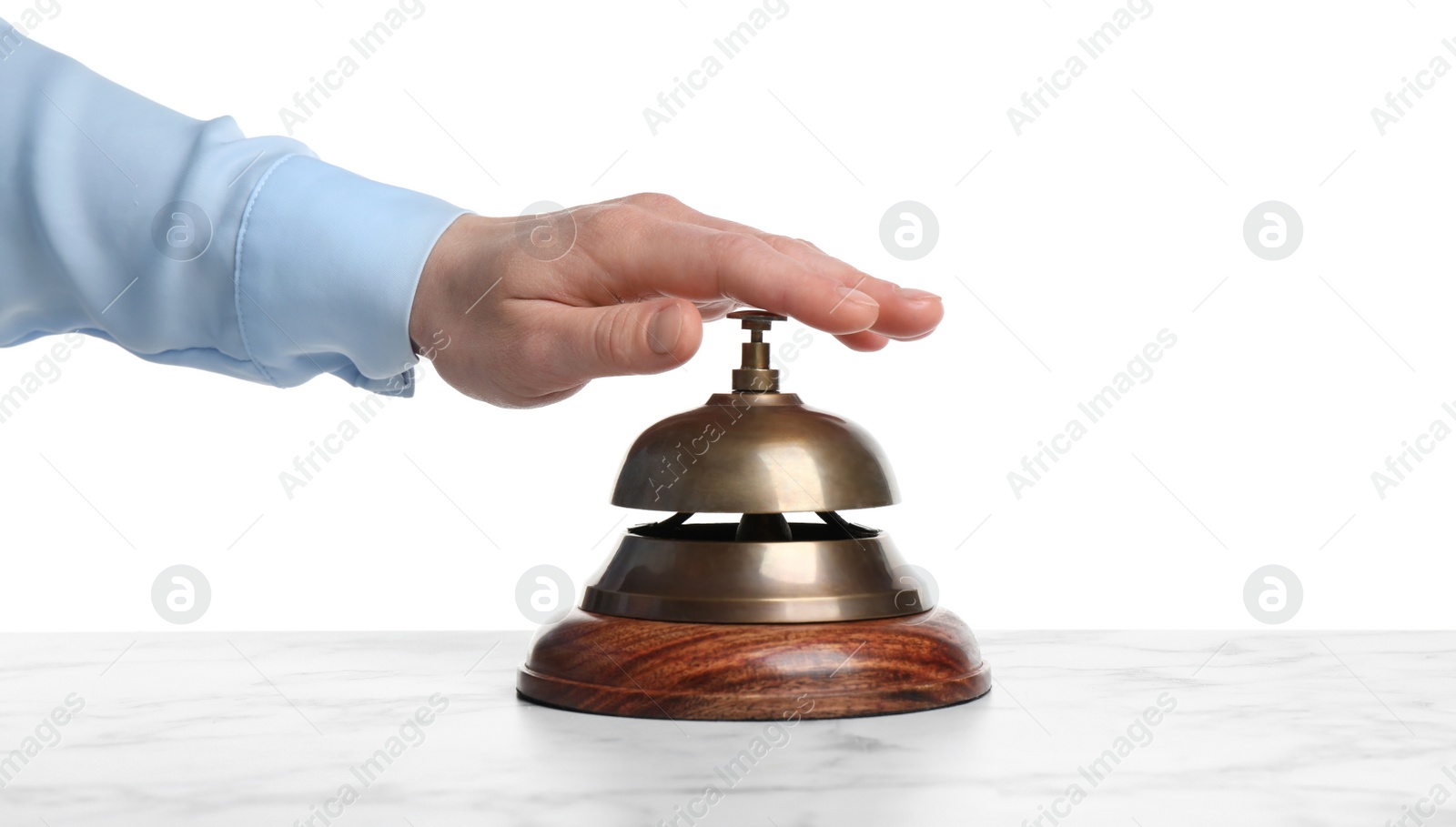 Photo of Man ringing hotel service bell at white marble table