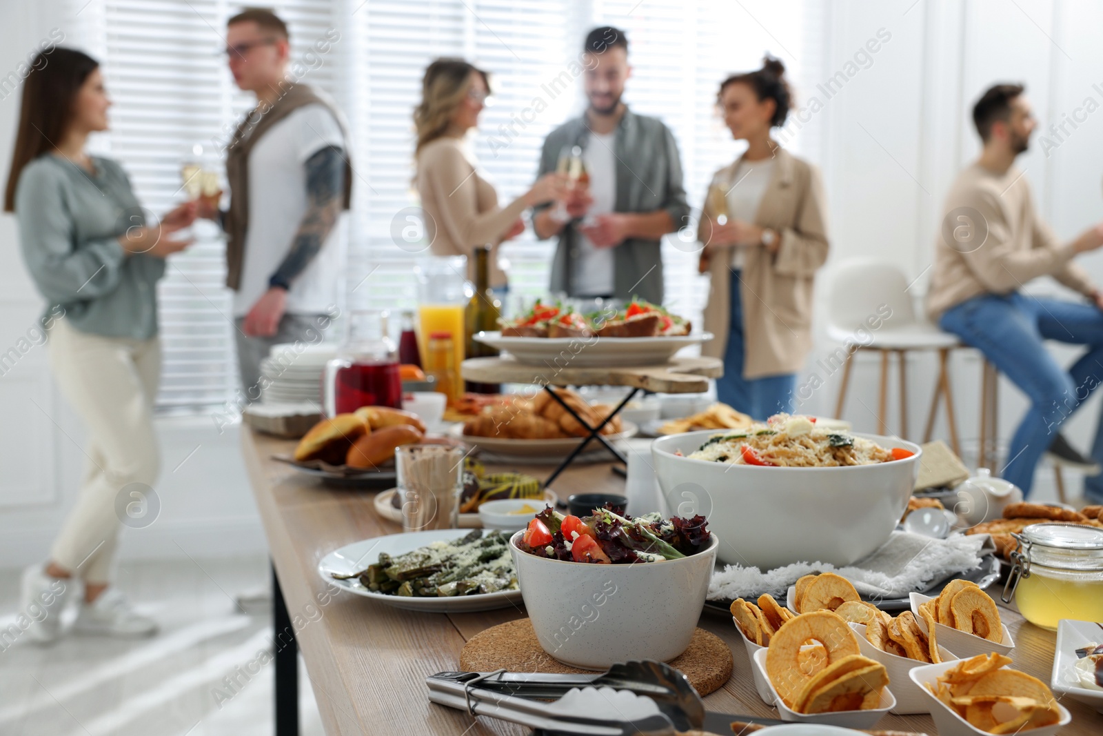 Photo of Brunch table setting with different delicious food	and blurred view of people on background