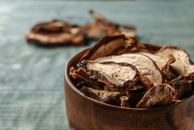 Photo of Bowl of dried mushrooms on table, closeup