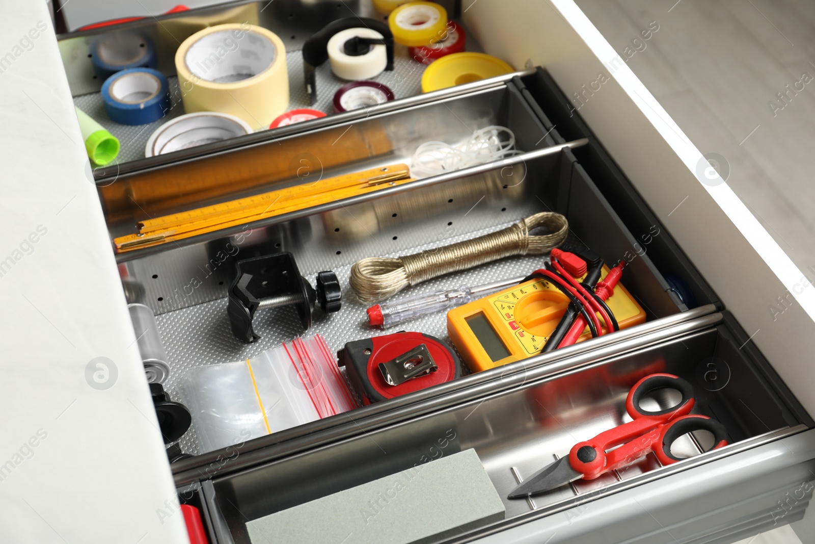 Photo of Set of instruments in open desk drawer indoors, closeup